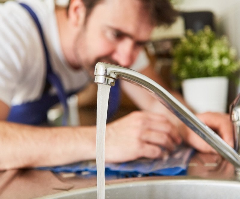 Rohrreinigung – Installateur prüft den Abfluss in der Küche
